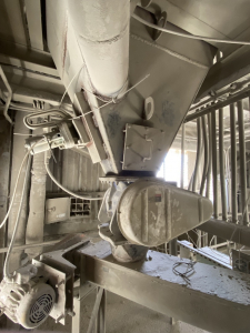 Some hoppers have an inlet above the discharge. Although many people are tempted to inject the precoat powder through this inlet, it is a very low location, there is not enough air volume to maintain the velocity needed to carry powder to the top section of the filter bags